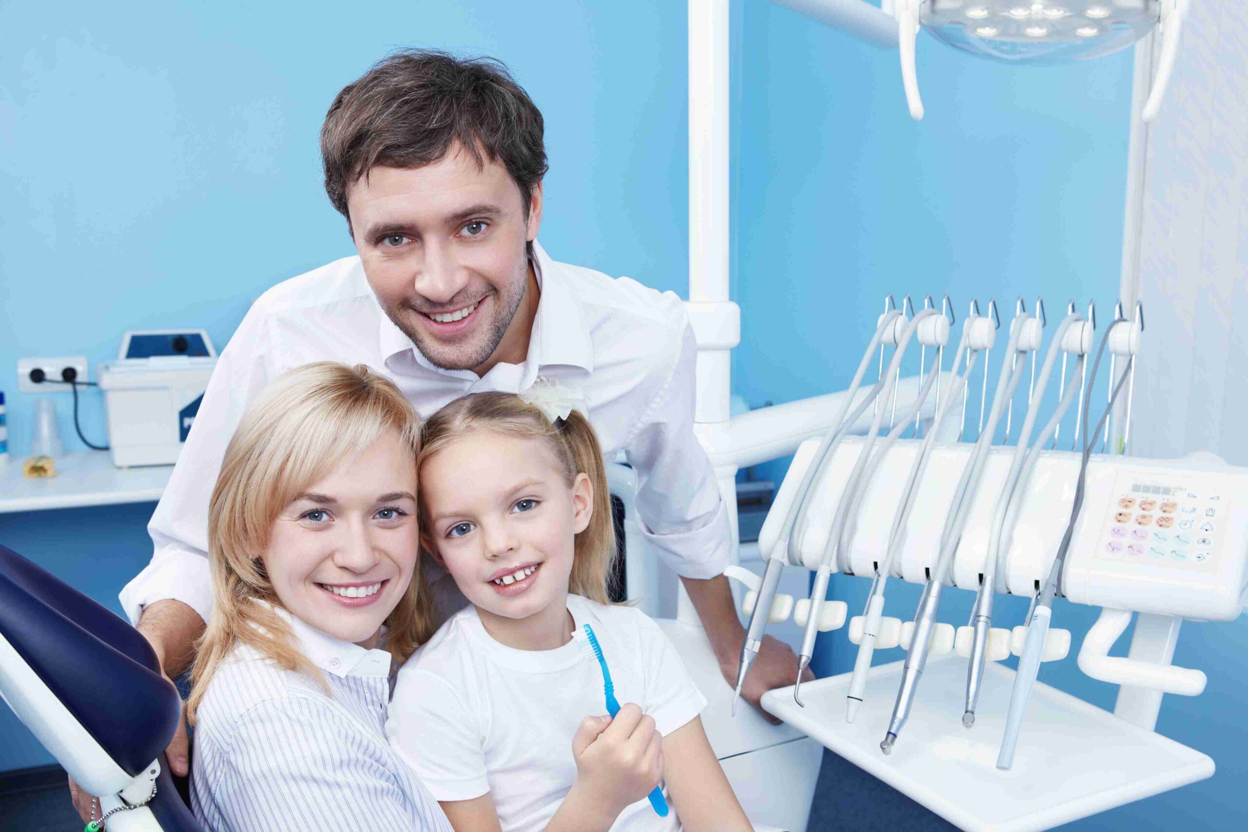 Pediatric dental examination with a mother and child in the treatment room.