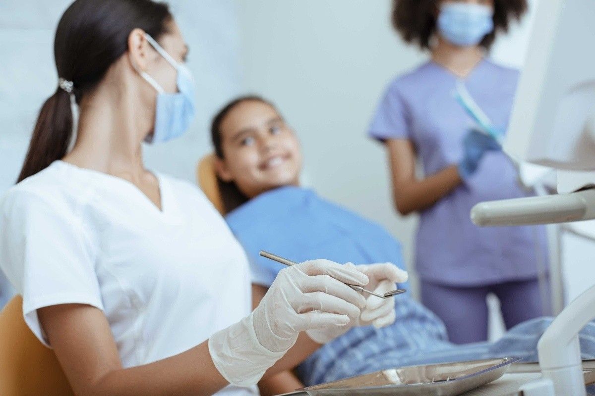 Child and parent meeting with a pediatric dental team during a dental visit