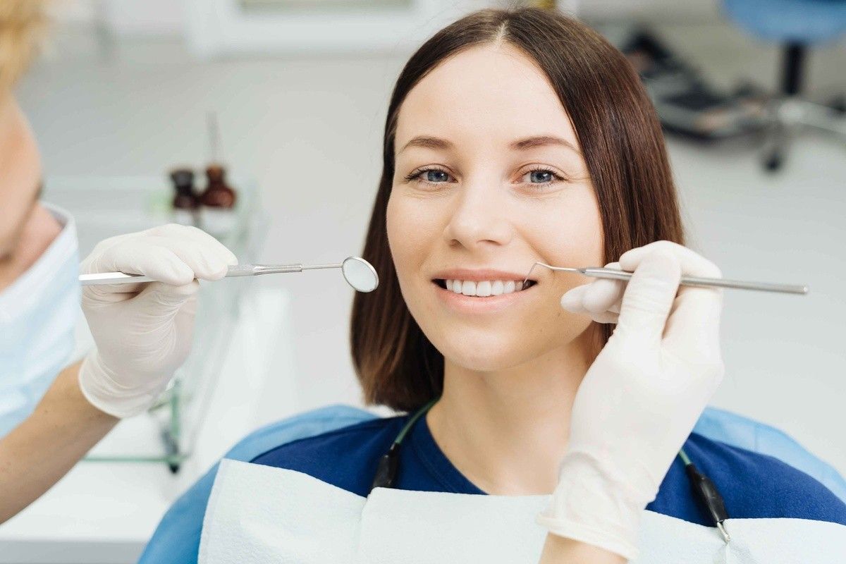 Dentist examining a young patient during a children's tooth restoration visit.